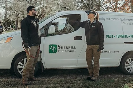 pest technicians talking next to Sherrill Pest van