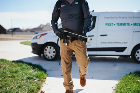 technician walking in to job to spray for pest